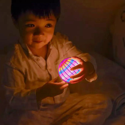 Child holding a colorful glowing ball in a dimly lit room